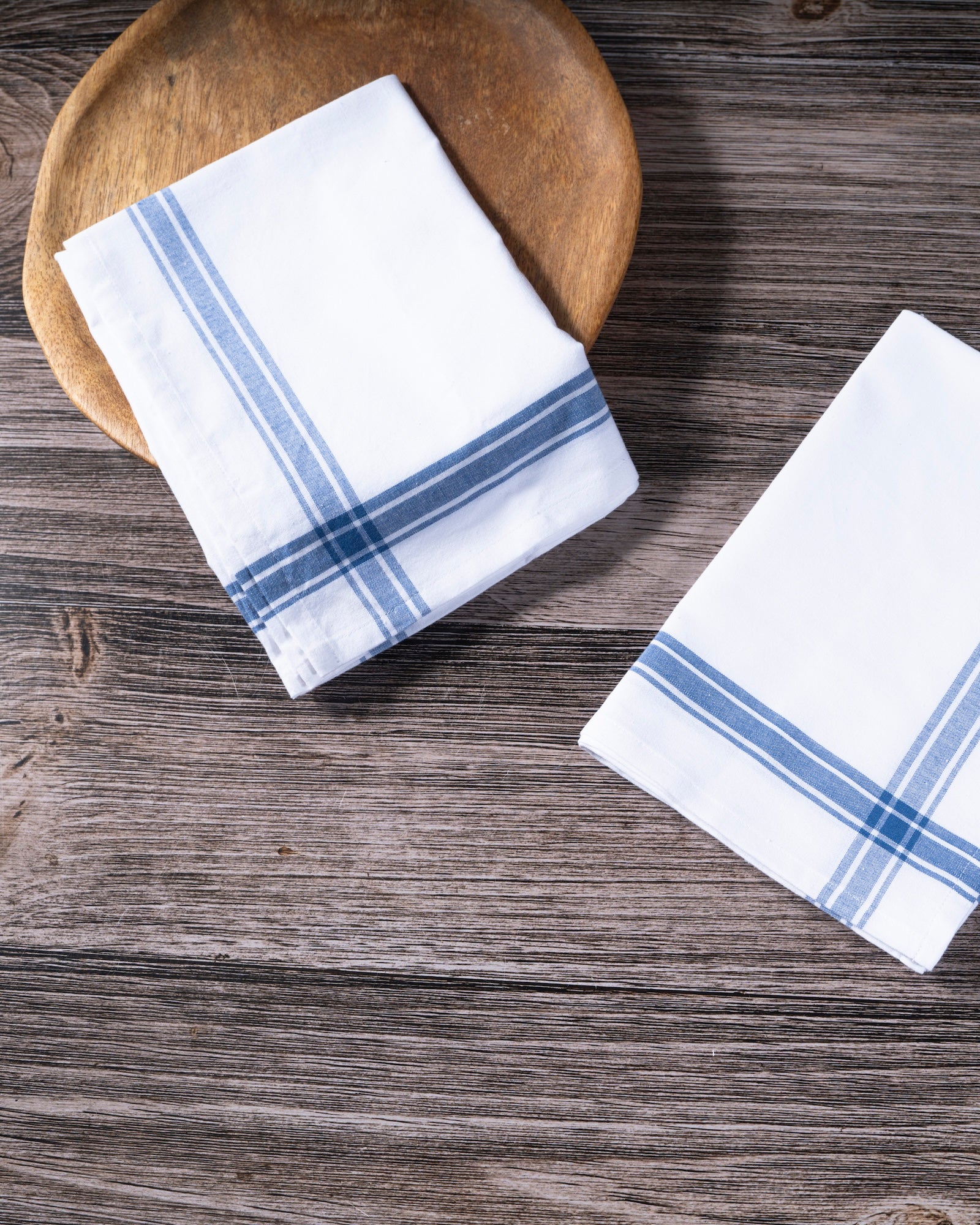 TerraKlay's White napkins with blue stripes on a wooden surface